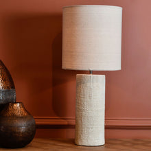 Load image into Gallery viewer, Showcasing a cylindrical base and a drum shade, this tall cream table lamp is elegant and versatile. The textured porcelain base is reminiscent of woven fabric and complements the plain cream shade perfectly, part of the Studio Electric homeware range.
